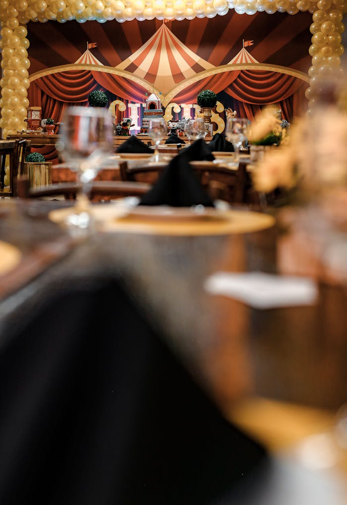 Elegant circus-themed party setup with detailed decor and tables indoors.